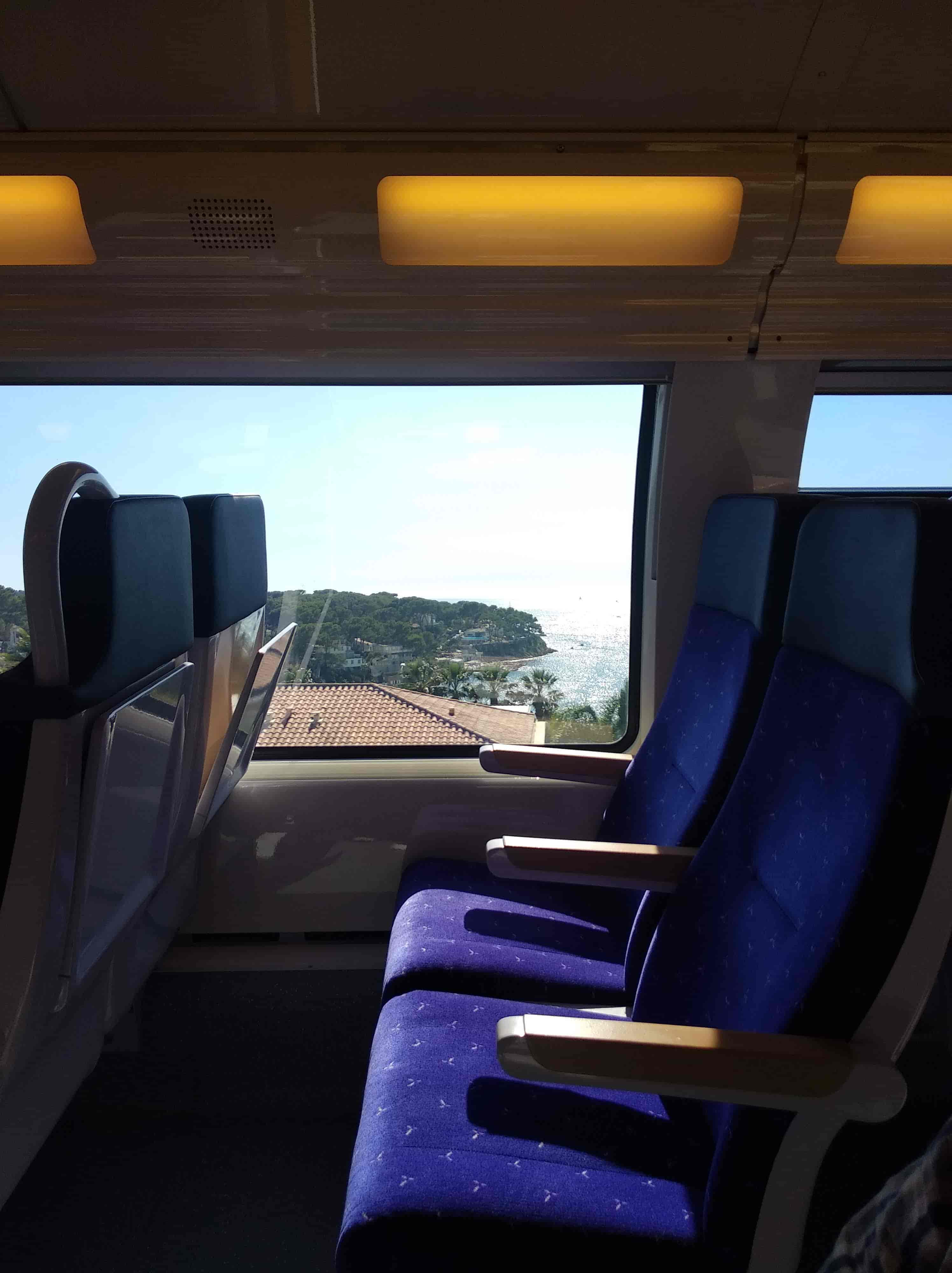 intérieur train, on aperçoit la mer par la fenêtre