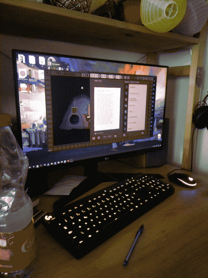 Une photo du bureau avec l'écran de l'ordinateur où tourne le jeu The longing en fenêtré.
