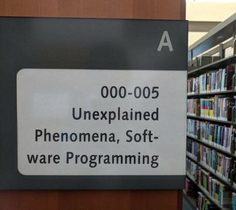 Un panneau d'une aile de bibliothèque où est inscrit: '000-005 Unexplained Phenomena, Software Programming'.